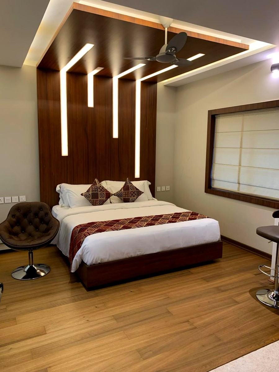 Master bedroom suite with wood headboard lighting